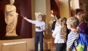 Tour guide in museum teaching students, illustrating piece on history education (Monkey Business Images/Shutterstock.com) spectator.org