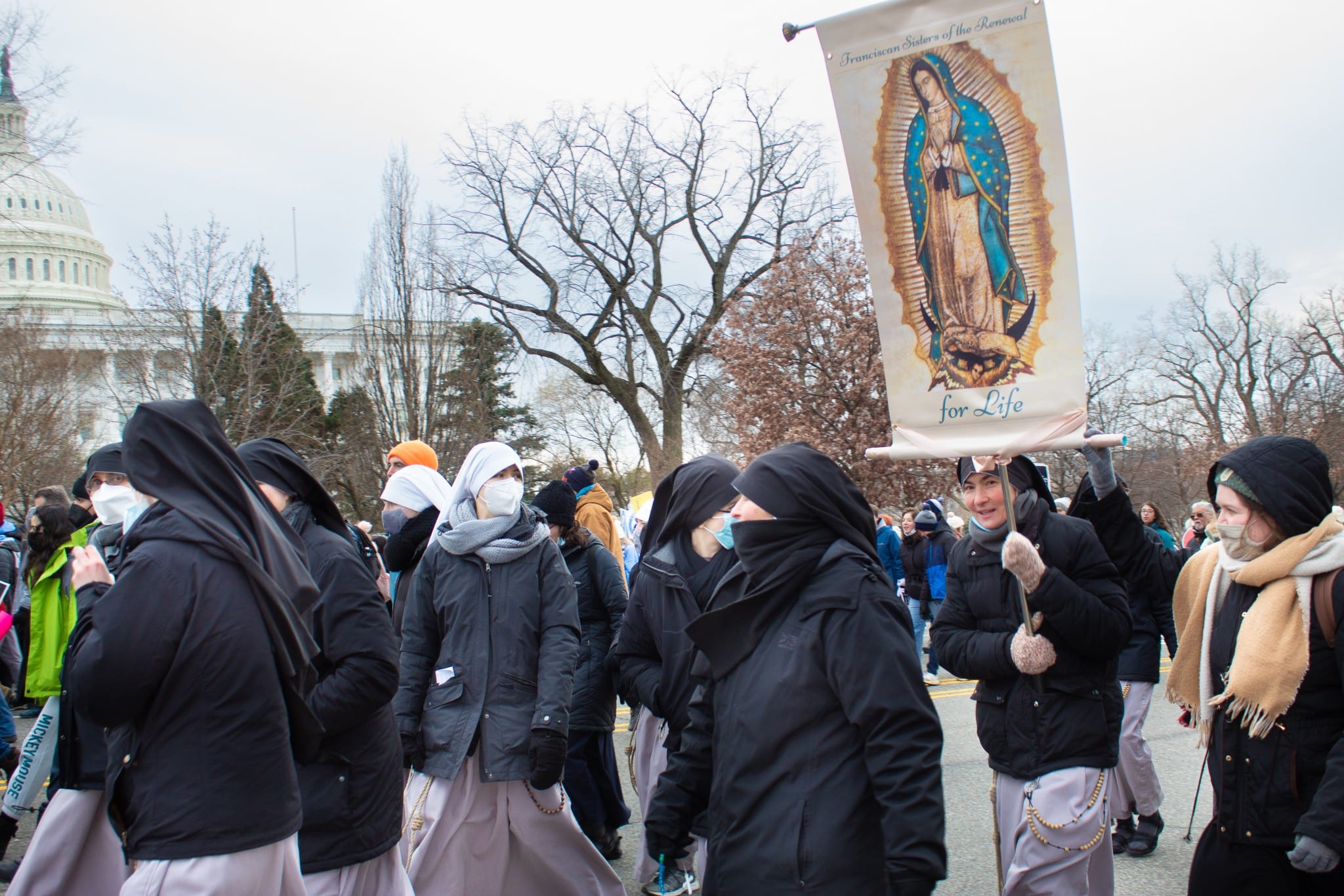 The Catholic Franciscan Sisters of the Renewal hold a banner depicting Our Lady of Guadalupe as they march in front of the Capitol Building on January 21, 2022. (The American Spectator) 