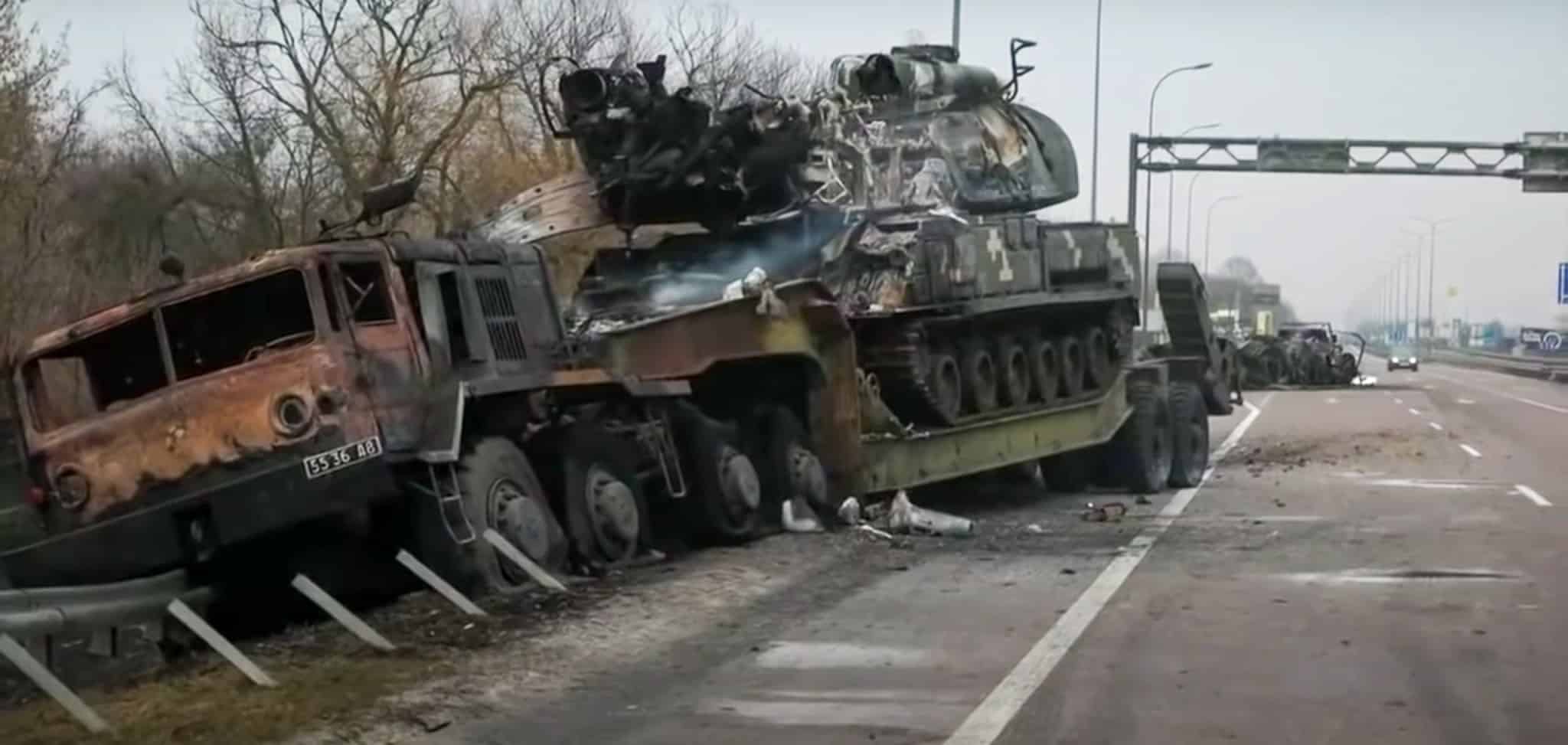 The smoking wreckage of a Russian vehicle lies by the side of the road in Ukraine. (BBC News/Youtube)