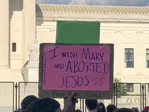 Pro-abortion protestor’s sign similar to other protestors who lambasted pro-life Christians with provocative messages including the one above wishing Mary aborted Jesus (Hunter Oswald/ The American Spectator)
