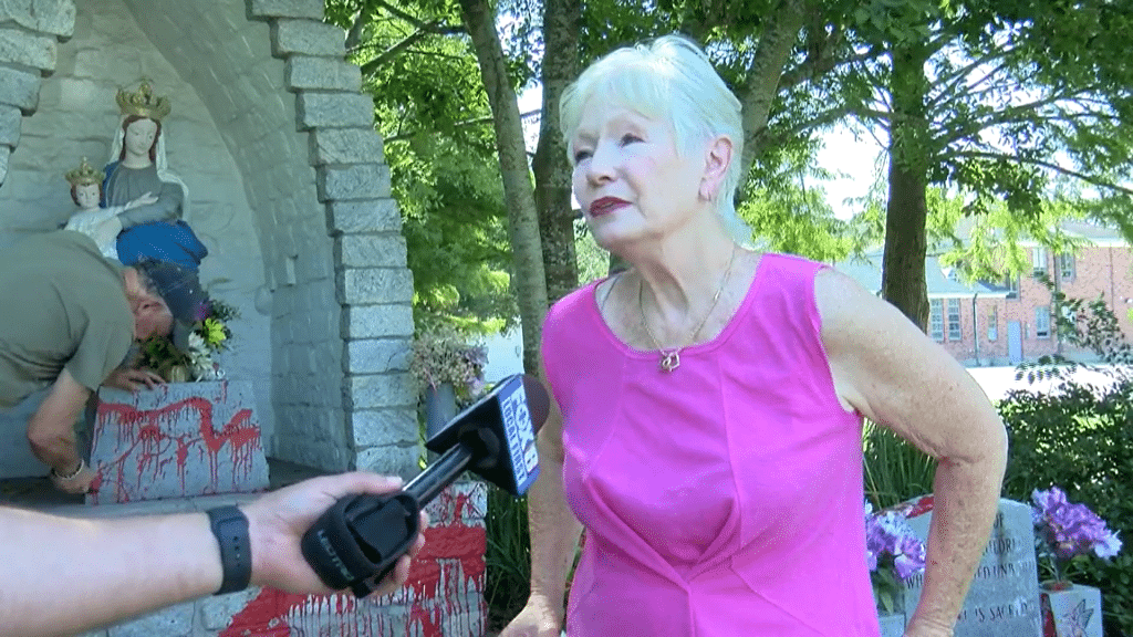 Volunteers work to clean the paint from the statue after it was defaced on June 25, 2022.