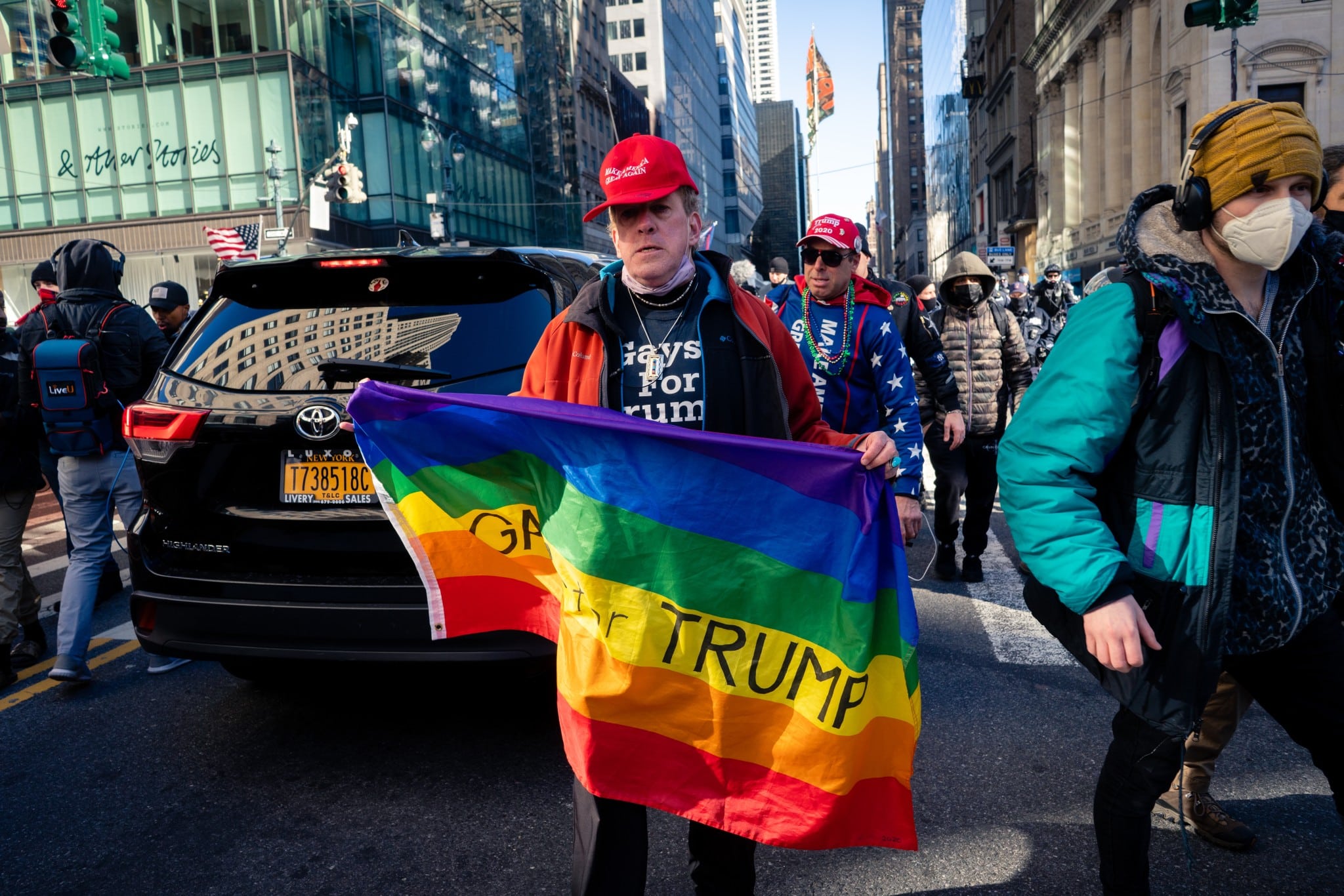 A Trump supporter marches in New York City on March 6, 2021, while carrying a “gays for Trump” flag. (Shutterstock/Wirestock Creators)