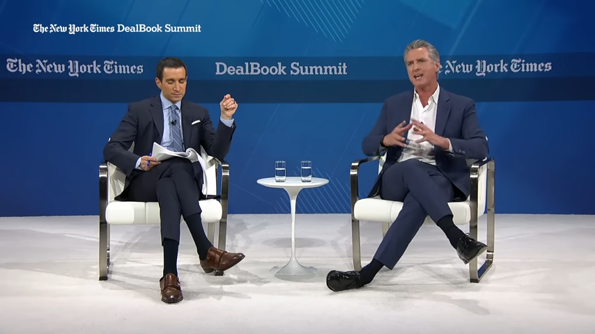 Two people discussing at DealBook Summit event.